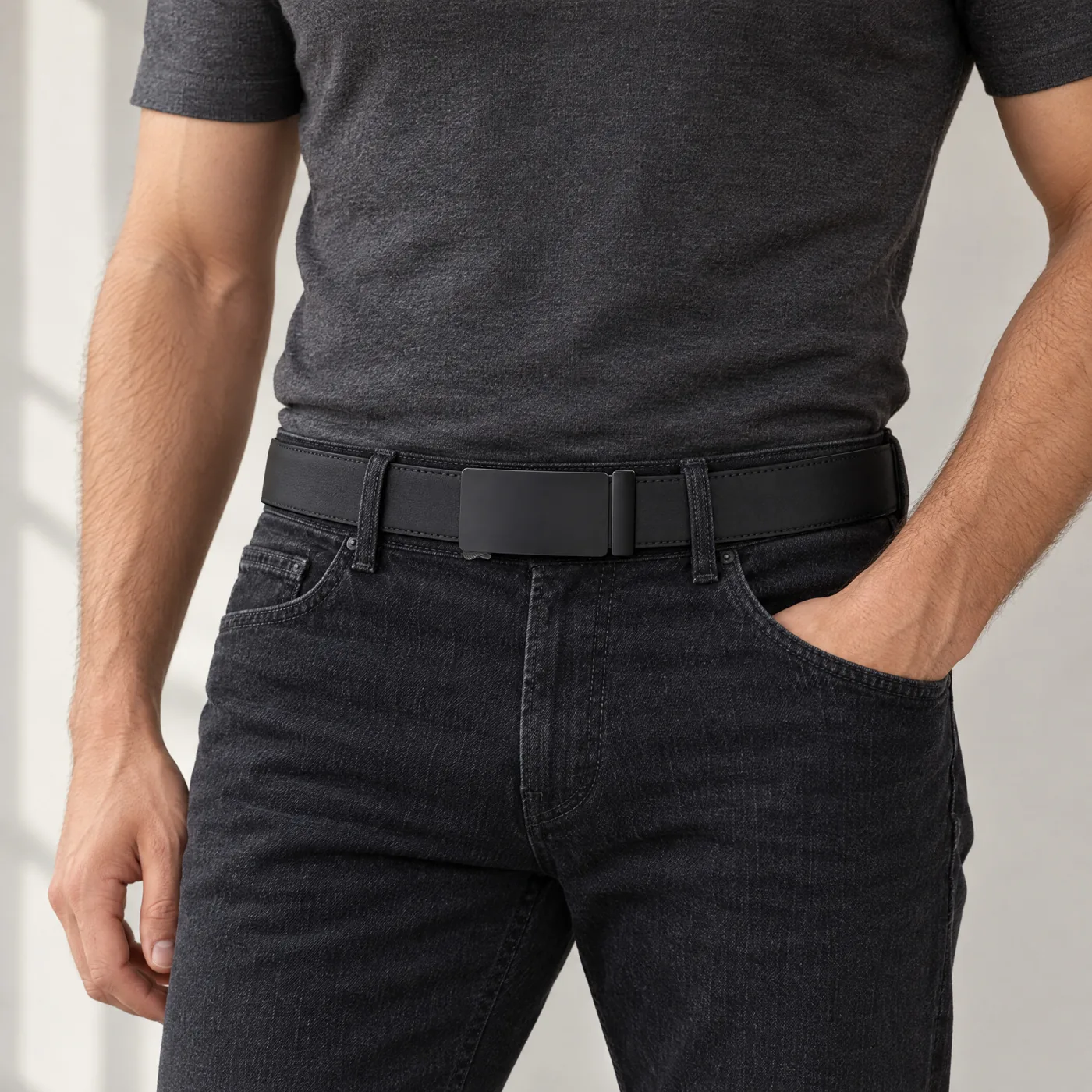 The Automatic Belt, matte black plate buckle worn with dark jeans (styled scene)