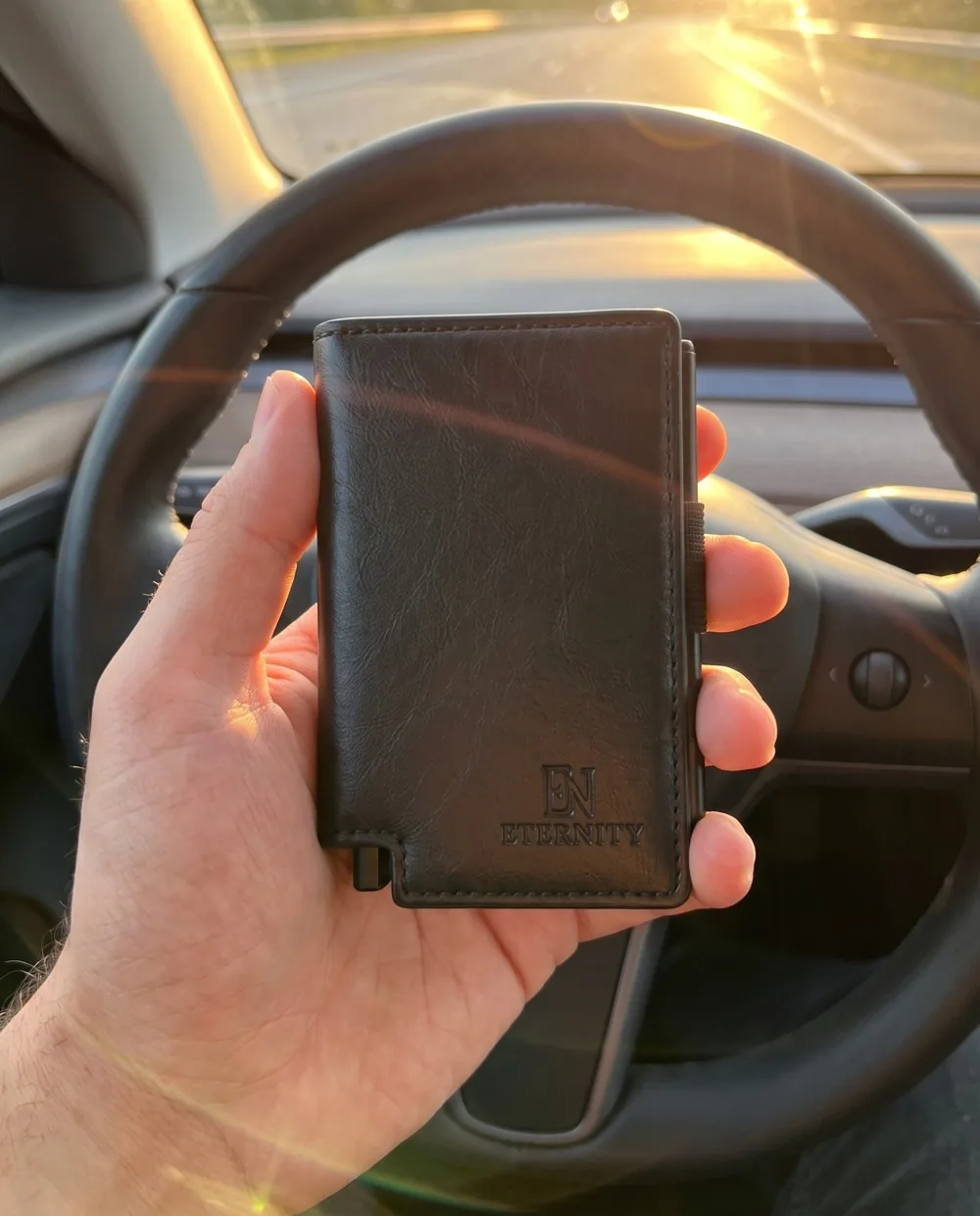 Luzof held in front of a steering wheel at golden hour