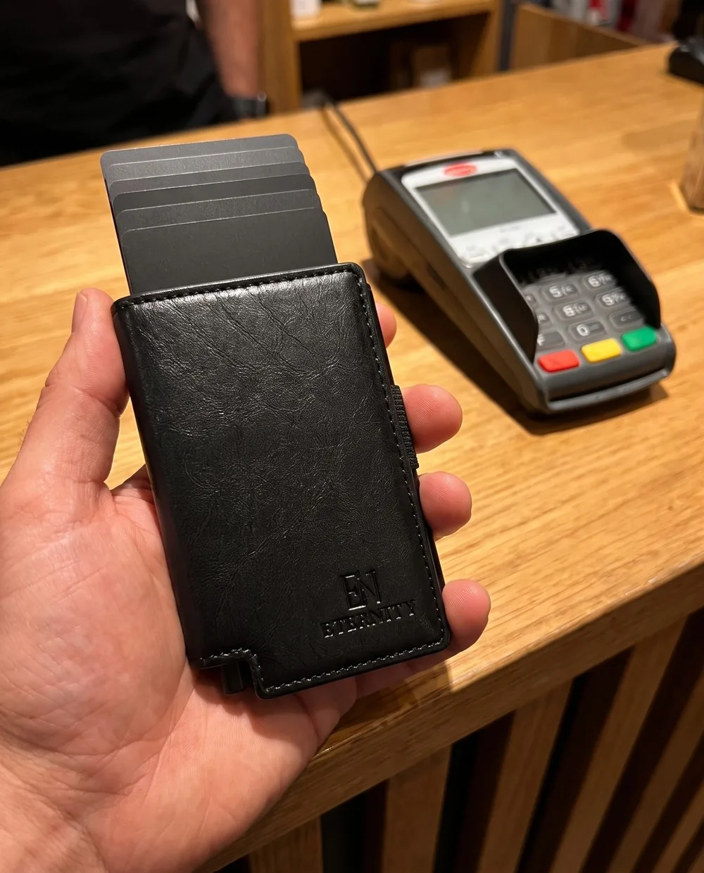 Luzof held at a shop counter with the cards raised